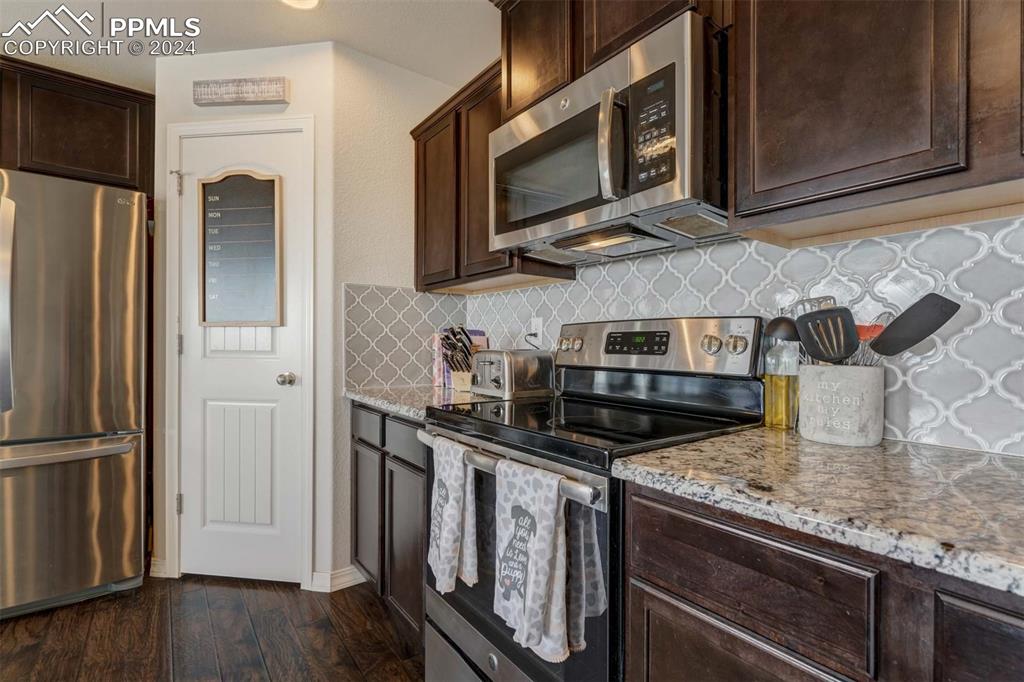 11305 Avena Road Peyton, CO 80831 - Photo 14 of 47 a kitchen with stainless steel appliances granite countertop a stove microwave and refrigerator