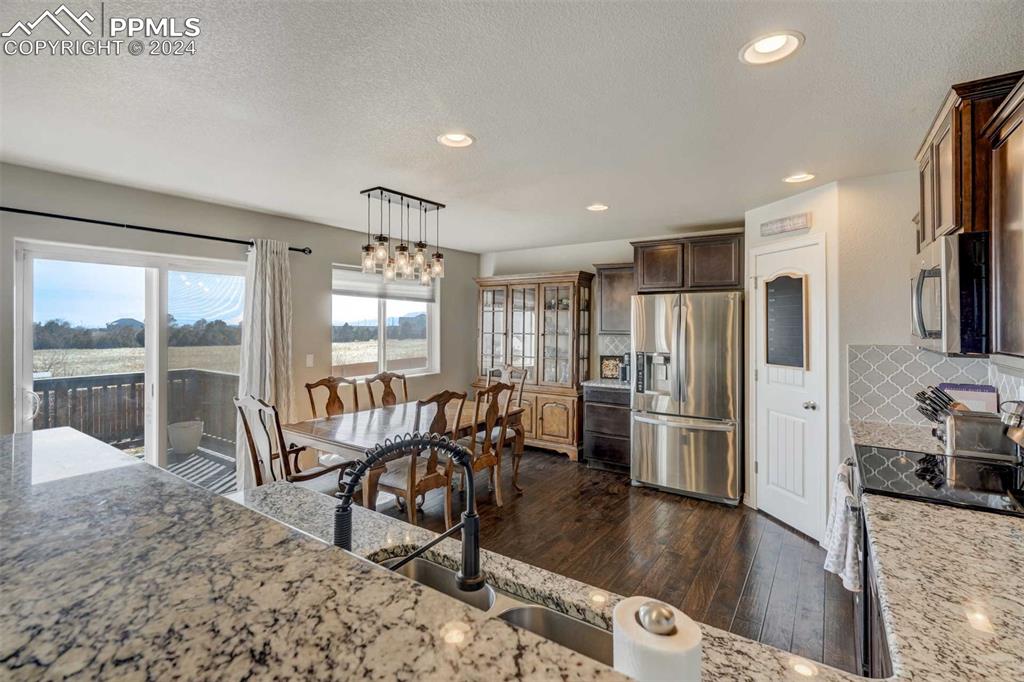11305 Avena Road Peyton, CO 80831 - Photo 15 of 47 a view of a kitchen with dining room and wooden floor