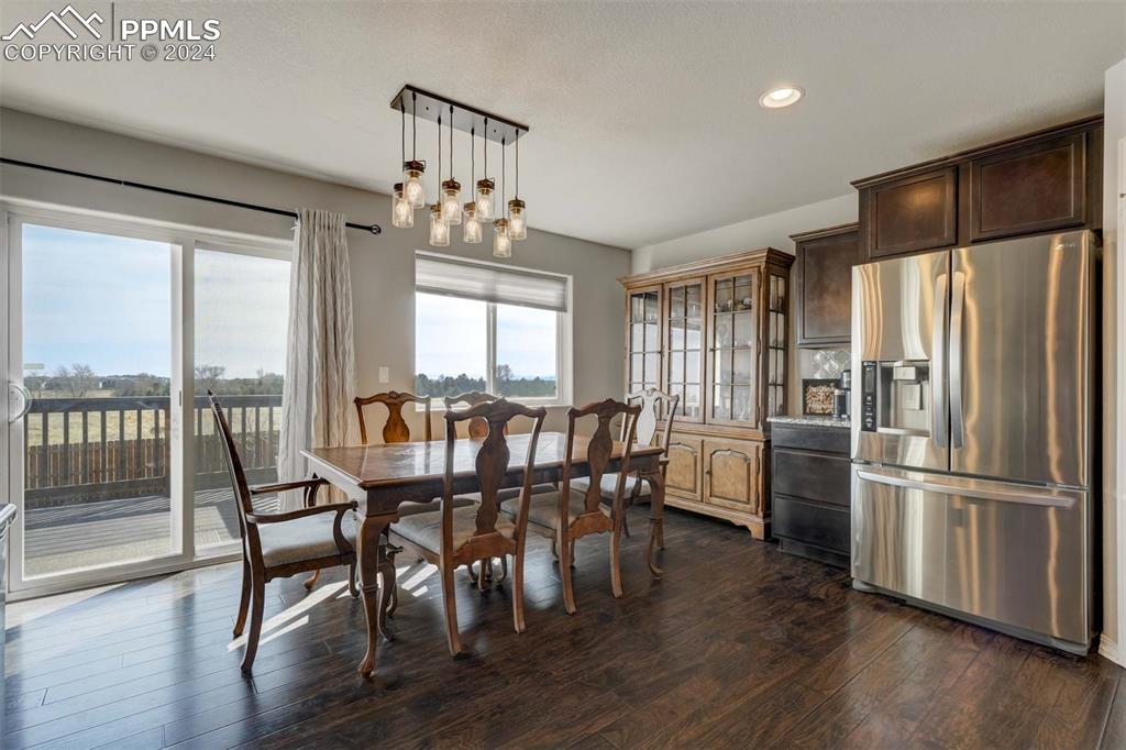 11305 Avena Road Peyton, CO 80831 - Photo 17 of 47 a dining room with furniture window wooden floor and a kitchen view