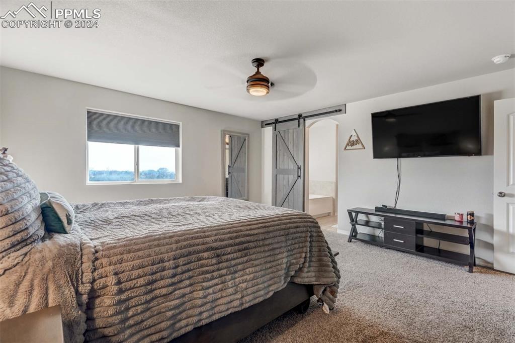 11305 Avena Road Peyton, CO 80831 - Photo 19 of 47 a bedroom with a bed and a flat screen tv