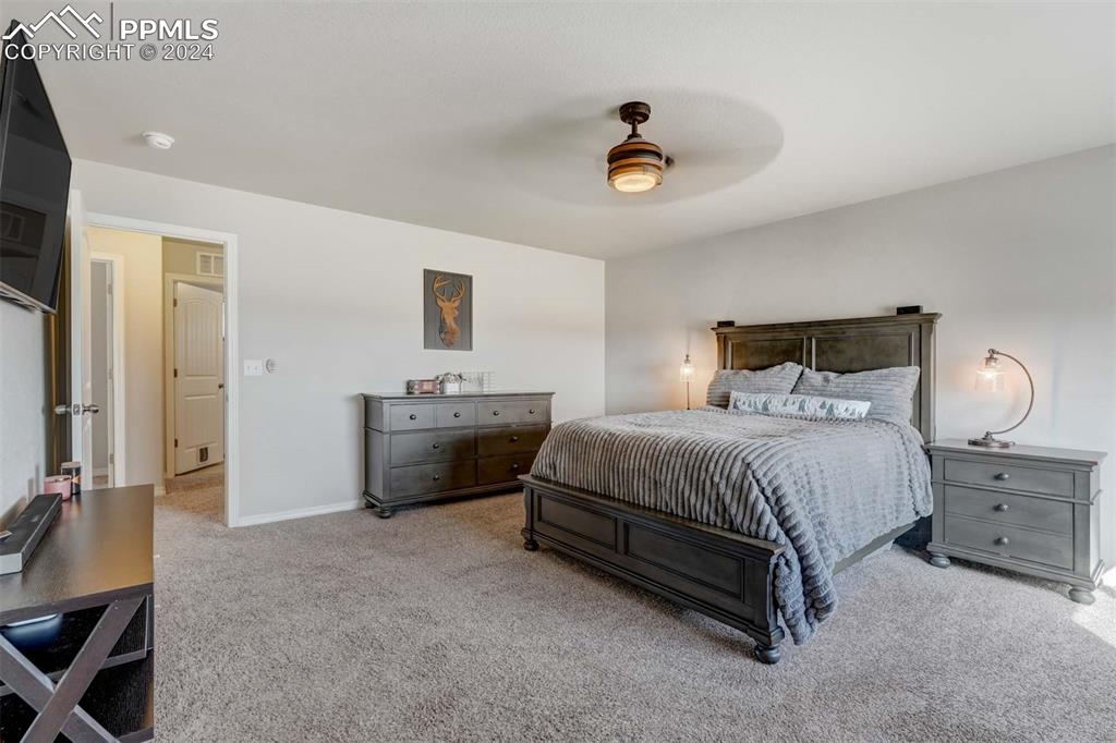 11305 Avena Road Peyton, CO 80831 - Photo 20 of 47 a bedroom with a bed and a chandelier