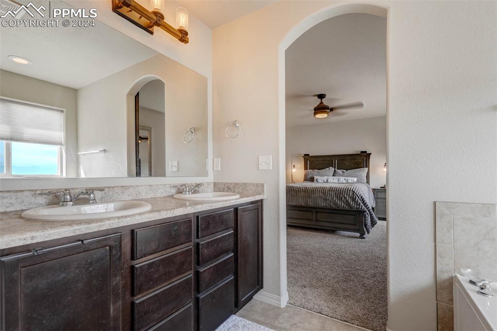 11305 Avena Road Peyton, CO 80831 - Photo 24 of 47 a en suite bathroom with a double vanity sink and a mirror