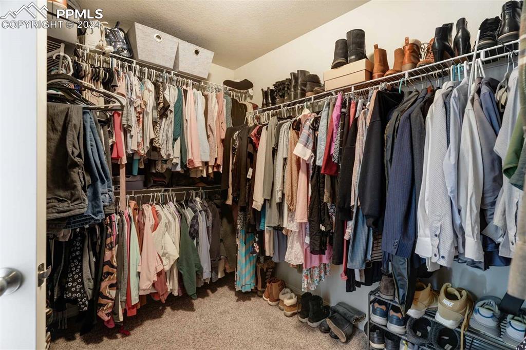 11305 Avena Road Peyton, CO 80831 - Photo 26 of 47 a view of walk in closet with clothes and shoes