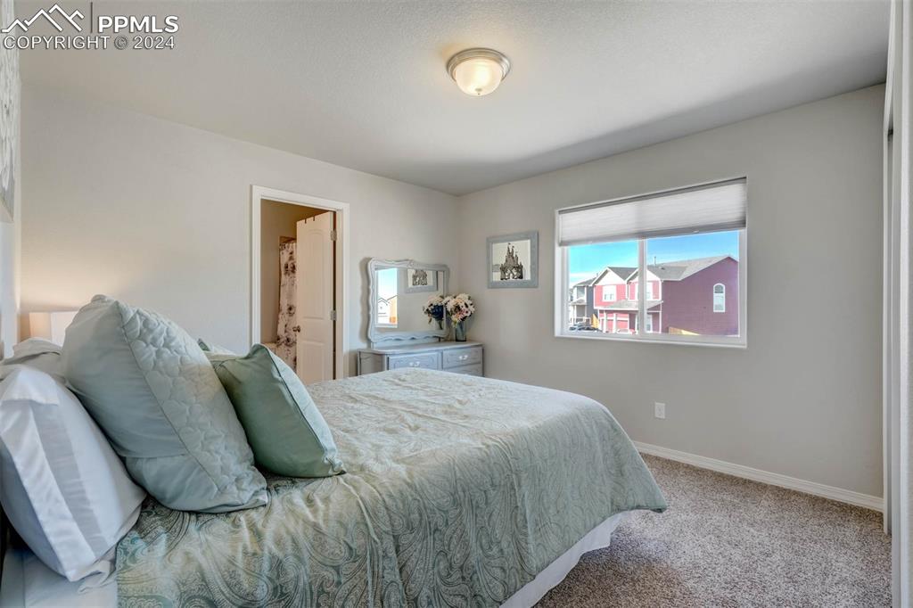 11305 Avena Road Peyton, CO 80831 - Photo 27 of 47 a bedroom with a bed and a painting on the wall