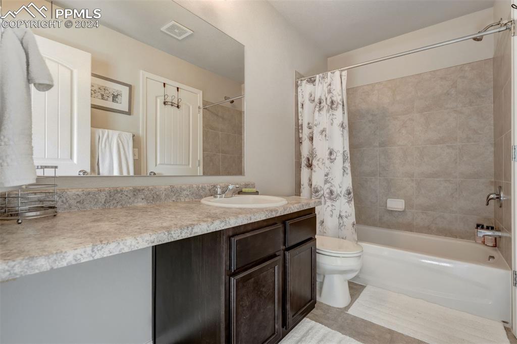 11305 Avena Road Peyton, CO 80831 - Photo 31 of 47 a bathroom with a granite countertop sink a toilet and shower