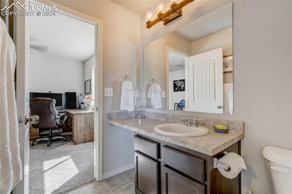 11305 Avena Road Peyton, CO 80831 - Photo 32 of 47 a bathroom with a sink a toilet and a mirror