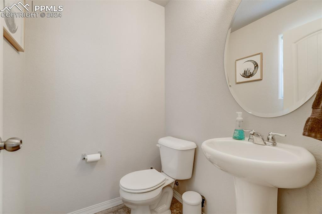 11305 Avena Road Peyton, CO 80831 - Photo 40 of 47 a bathroom with a toilet a sink and mirror