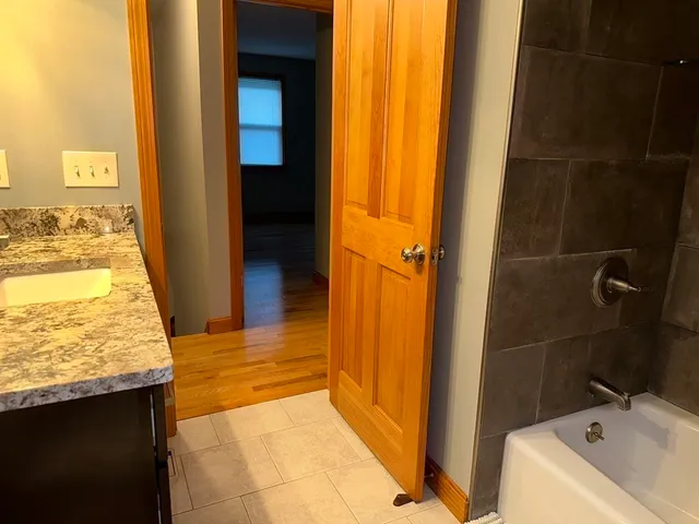 a bathroom with a granite countertop sink and a mirror