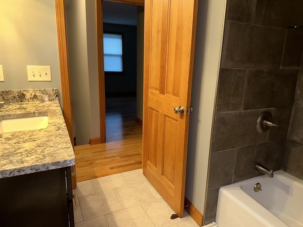 101 Minechoag Heights, Unit 101 Ludlow, MA 01056 - Photo 11 of 20 a bathroom with a granite countertop sink and a mirror