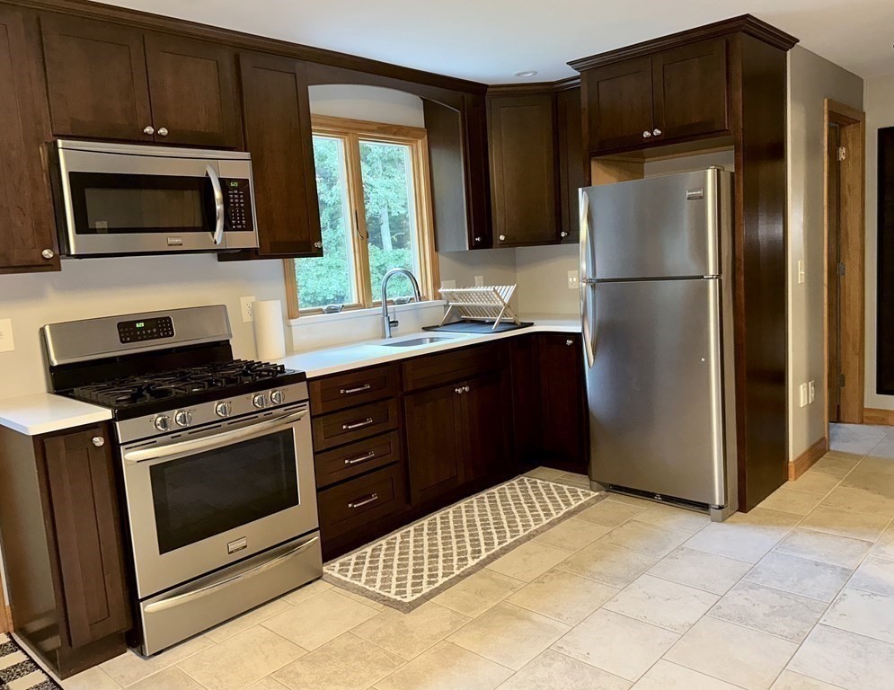 101 Minechoag Heights, Unit 101 Ludlow, MA 01056 - Photo 3 of 20 a kitchen with stainless steel appliances a refrigerator a stove a microwave a sink and cabinets