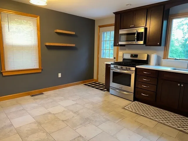 a kitchen with stainless steel appliances a stove sink and microwave