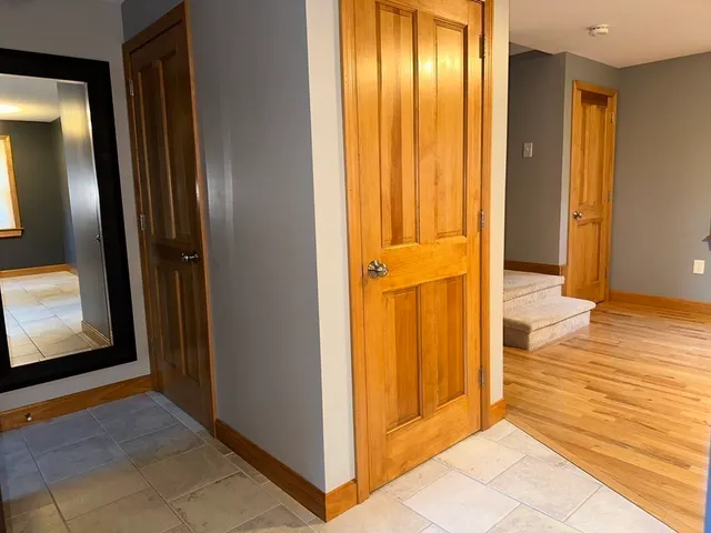 a view of a hallway with wooden floor and doors