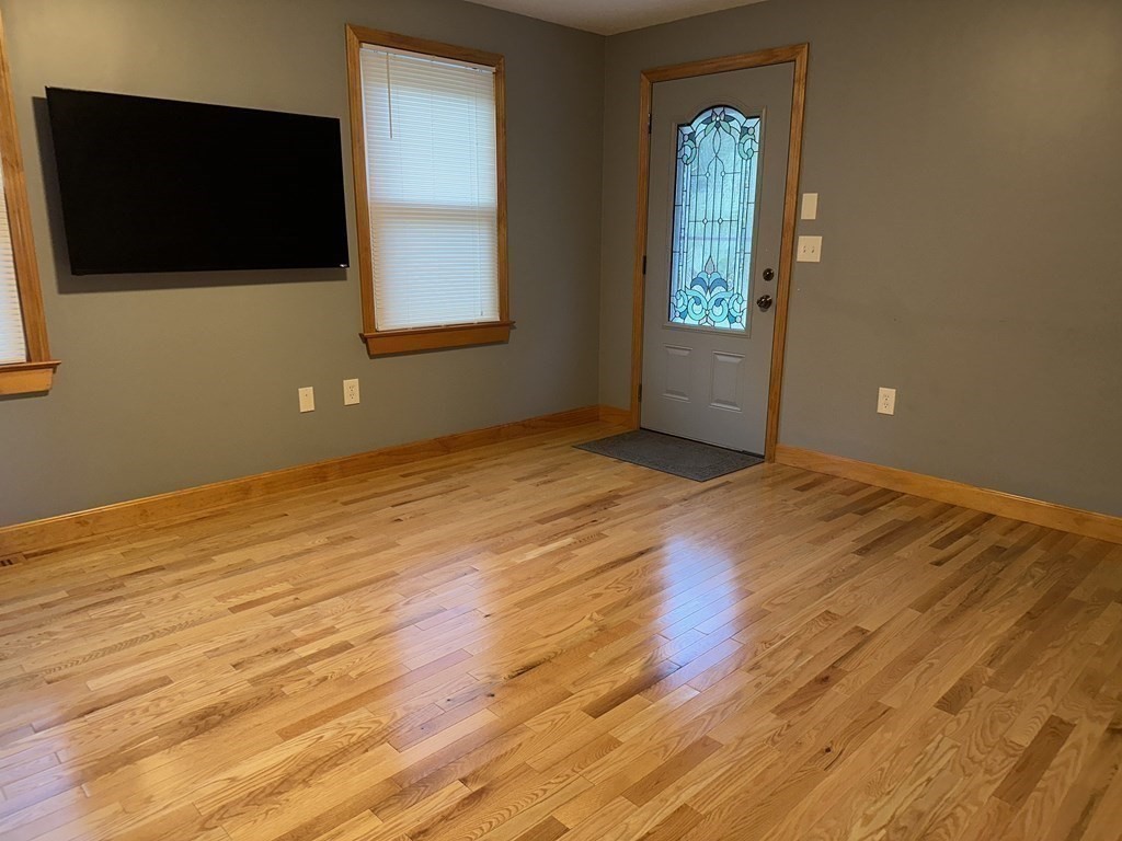 101 Minechoag Heights, Unit 101 Ludlow, MA 01056 - Photo 8 of 20 a view of an empty room with wooden floor and a window