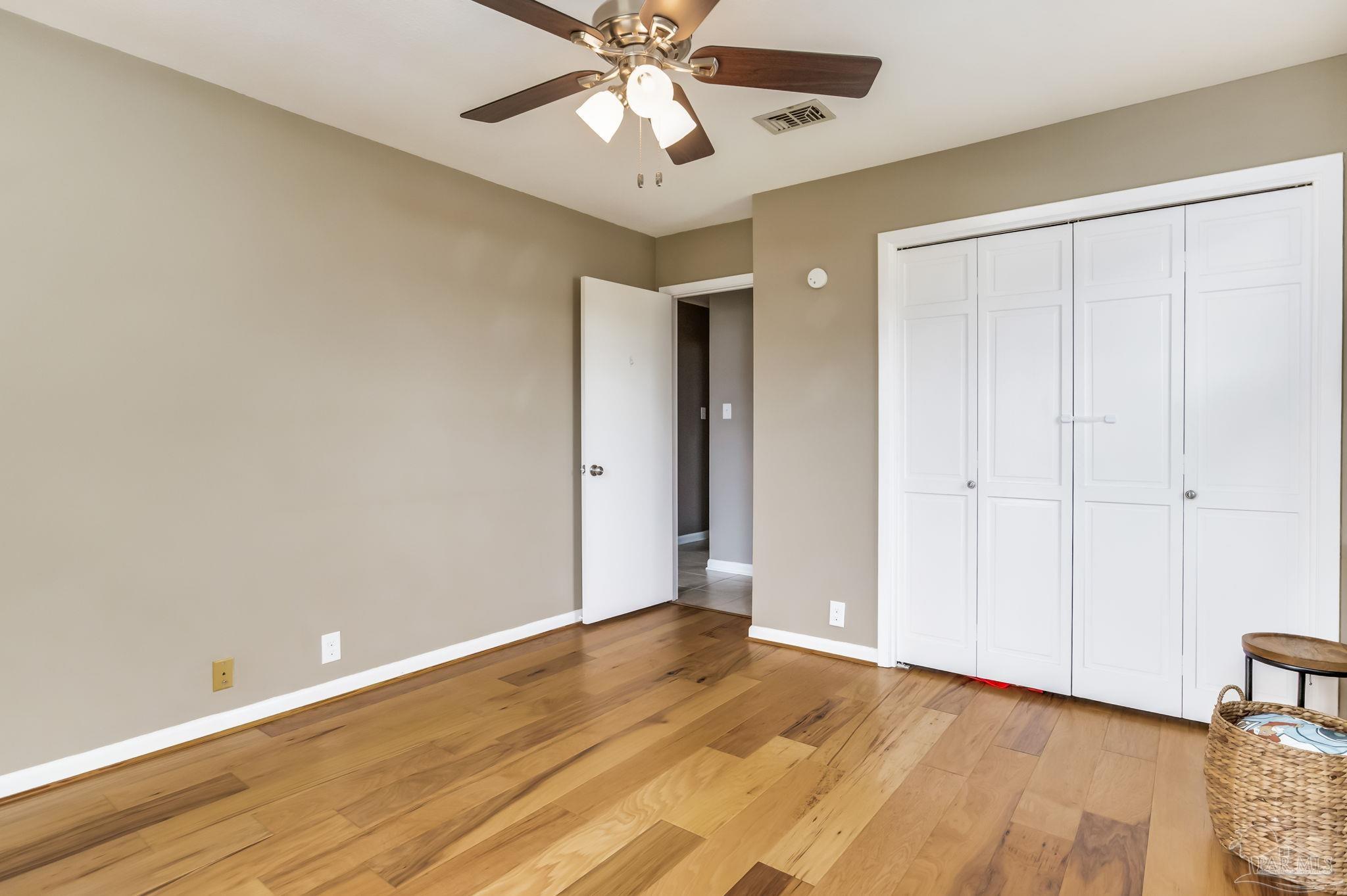 3525 Hopestill Road Pensacola, FL 32503 - Photo 12 of 20 an empty room with wooden floor fan and windows