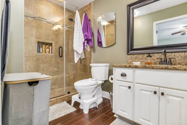 a bathroom with a toilet sink vanity and mirror