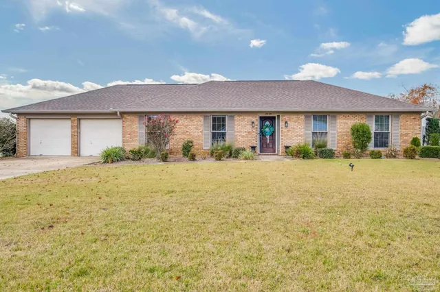 a front view of a house with a yard and potted plants