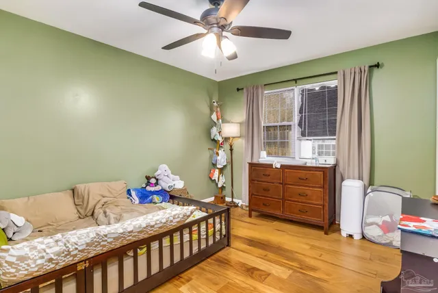 a bedroom with a bed and wooden floor