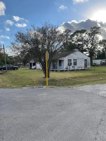 a view of a large house with a big yard and large trees