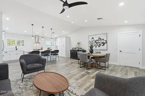 a living room with furniture and a dining table with rug