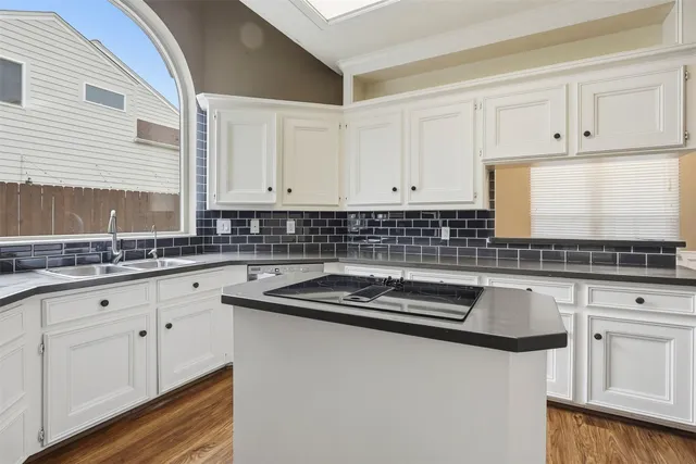 a kitchen with granite countertop white cabinets and white appliances