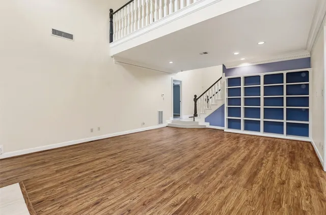 a view of empty room with wooden floor and windows
