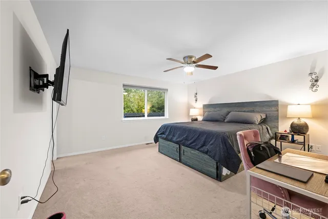 a spacious bedroom with a bed and a chandelier