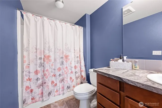 a bathroom with a granite countertop sink toilet and a mirror