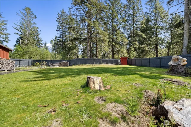 a view of a back yard with a wooden fence