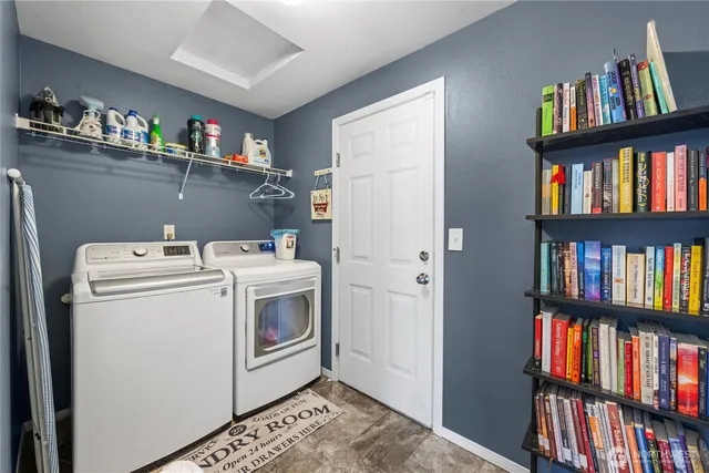 a utility room with dryer and book shelf