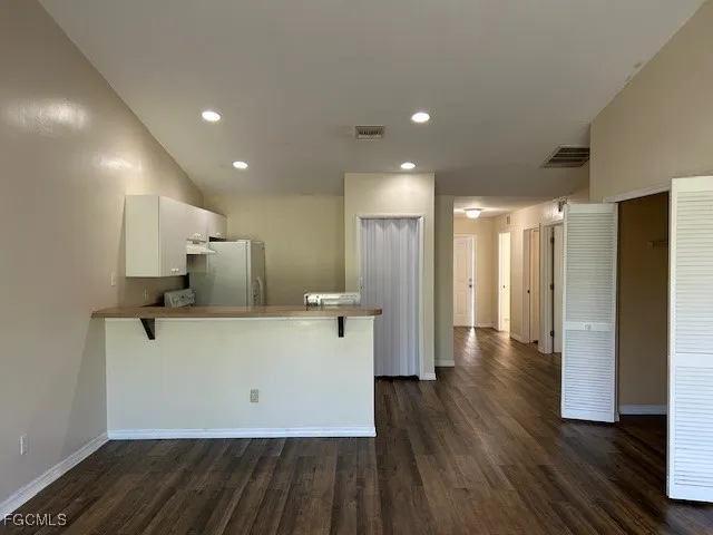 a view of kitchen with refrigerator stove and wooden cabinets