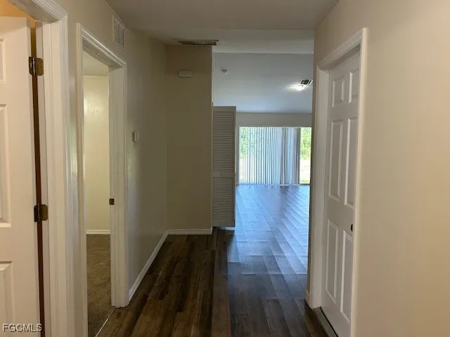 a view of a hallway with wooden floor