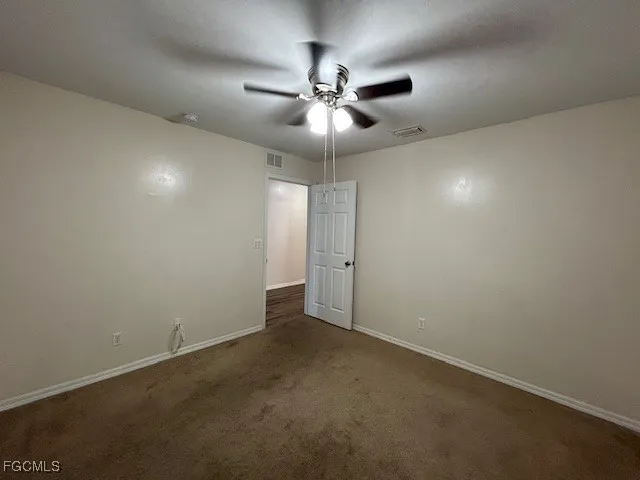 an empty room with a fan and a fan