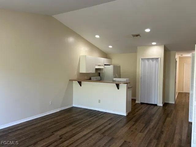 a view of a kitchen with wooden floor and a sink
