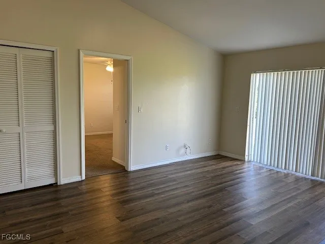 an empty room with wooden floor & windows