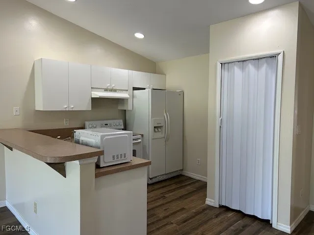a kitchen with a refrigerator a sink and wooden cabinets