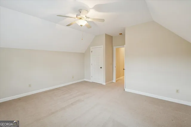 a view of an empty room with a chandelier fan