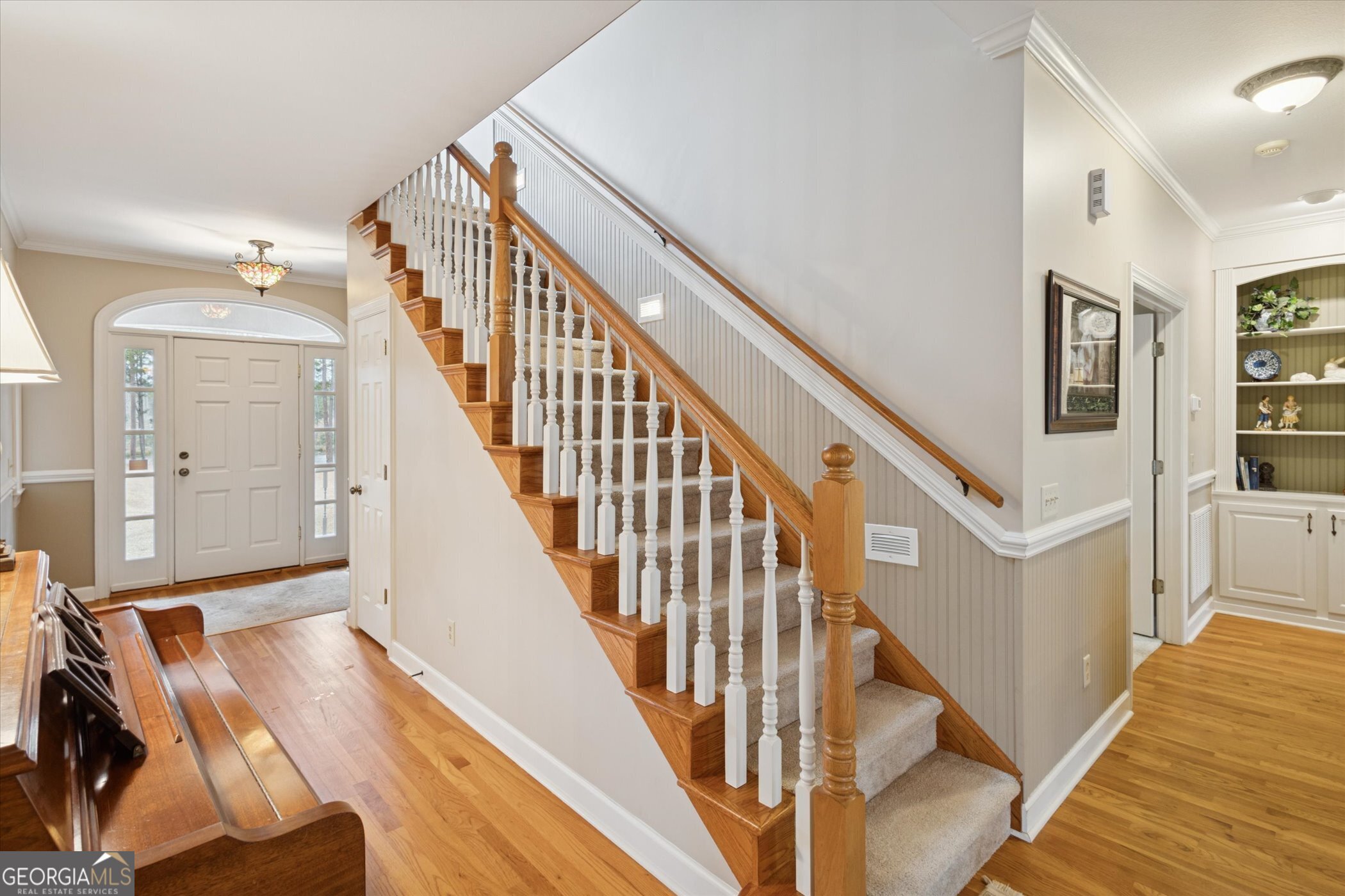 10544 Burkhalter Road Statesboro, GA 30461 - Photo 7 of 67 a view of staircase with lots of frames on wall and wooden floor