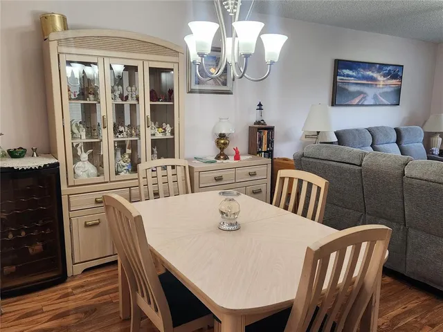a view of a dining room with furniture a chandelier and wooden floor