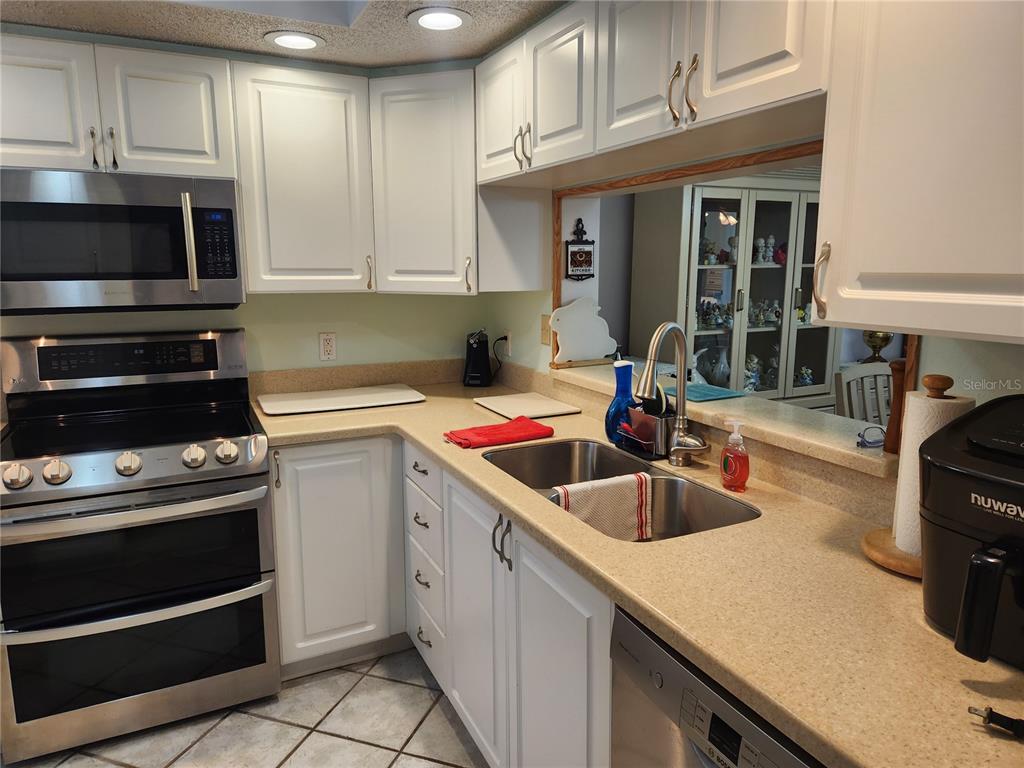 6505 Stone River Road, Unit 304 Bradenton, FL 34203 - Photo 6 of 38 a kitchen with granite countertop a sink dishwasher stove and cabinets