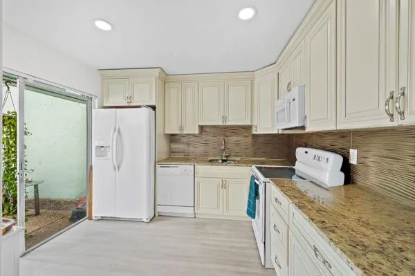 a kitchen with a refrigerator sink and cabinets