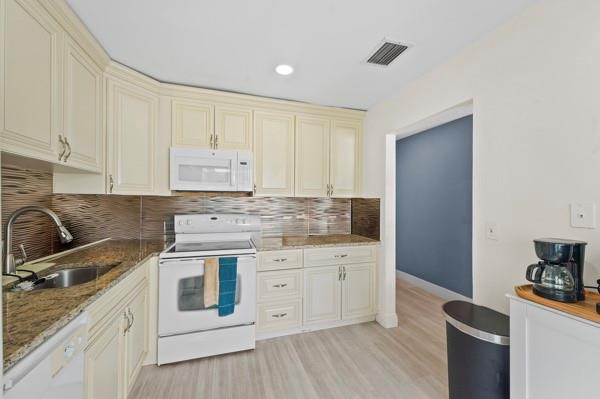9302 Southwest 5th Street, Unit B Boca Raton, FL 33428 - Photo 13 of 26 a kitchen with granite countertop white cabinets and white appliances