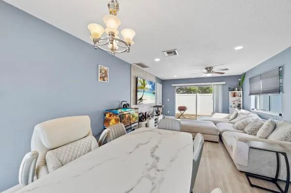 a living room with furniture a chandelier and a window