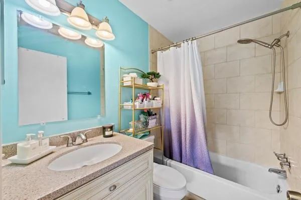 a bath room with a sink a toilet and shower