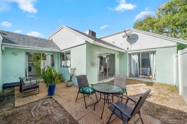 a view of a house with backyard and sitting area