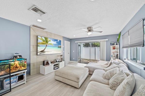 9302 Southwest 5th Street, Unit B Boca Raton, FL 33428 - Photo 8 of 26 a spacious bedroom with a bed and a flat tv screen on the dresser