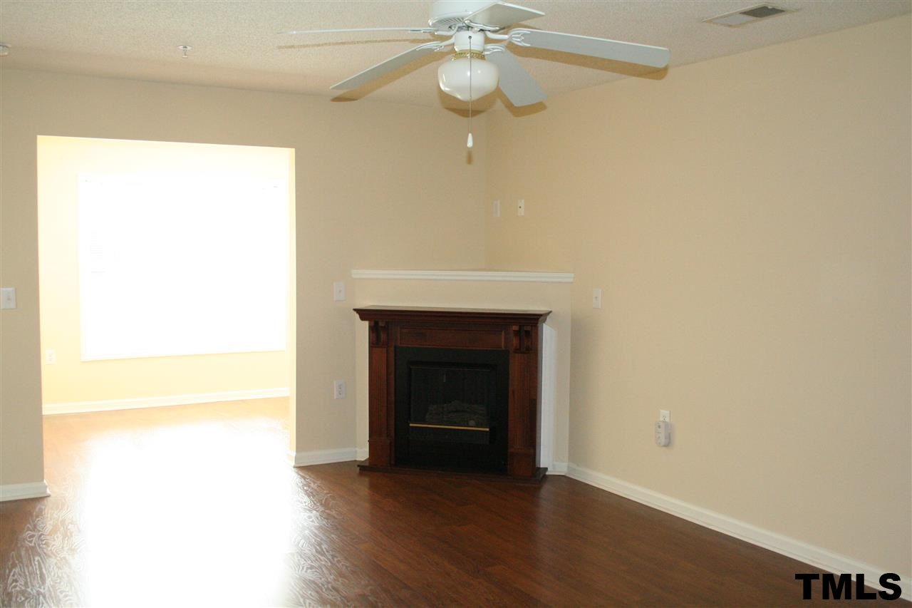 2500 Huntscroft Lane, Unit 101 Raleigh, NC 27617 - Photo 5 of 22 a view of an empty room with wooden floor and a fireplace