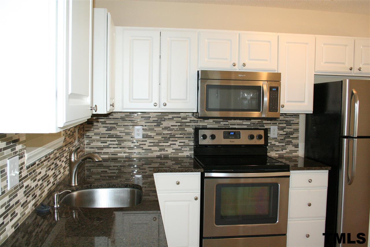 2500 Huntscroft Lane, Unit 101 Raleigh, NC 27617 - Photo 8 of 22 a kitchen with granite countertop a stove microwave and cabinets