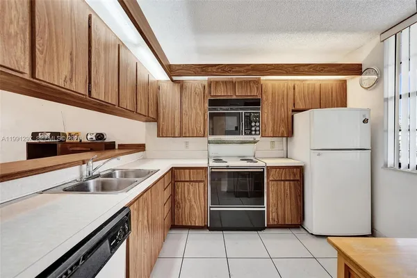 a kitchen with stainless steel appliances granite countertop a refrigerator sink and stove