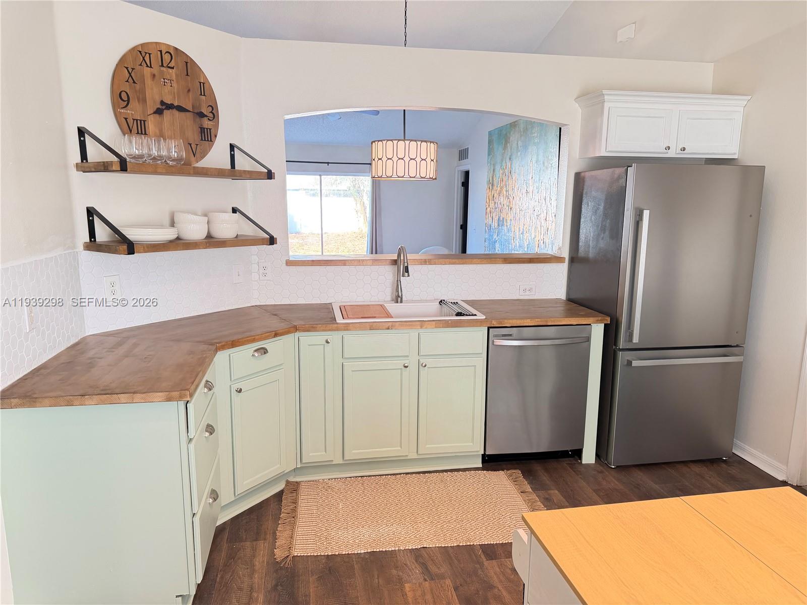 7 Zeidler Place Palm Coast, FL 32164 - Photo 5 of 26 a kitchen with a sink a refrigerator and cabinets