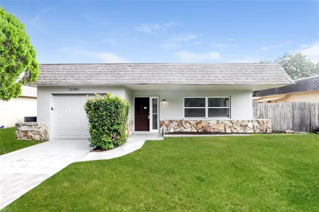 a front view of a house with a garden and yard
